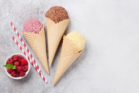 Chocolate strawberry and butterscotch flavoured ice cream cones with berries on side