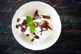 Vanilla ice cream with chocolate drizzle and mint leaves on top