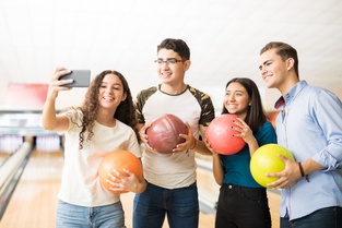 4 people taking selfie with bowling balls