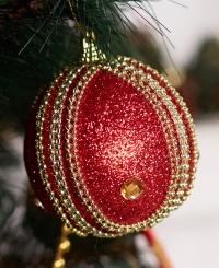 Red and gold ball ornament hanging on tree