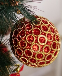 Red and gold ball ornament hanging on tree
