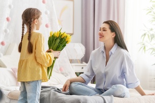Daughter giving flowers t to her mom
